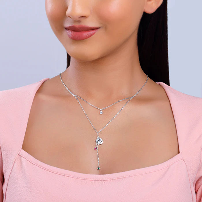 Woman wearing a silver necklace with a heart pendant on a light gray background