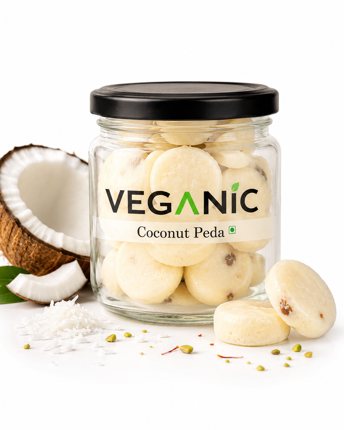 Jar of Veganic Coconut Peda with a coconut and pieces of coconut on a white background